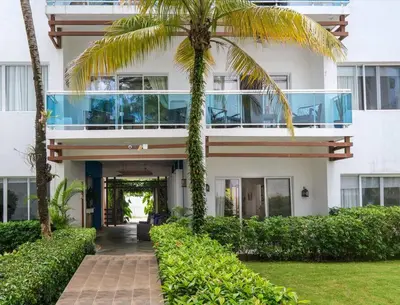 a building with a palm tree in front of it at Las Terrenas Haven in Las Terrenas