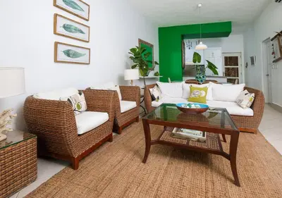a living room with wicker chairs and a coffee table at Las Terrenas Haven in Las Terrenas