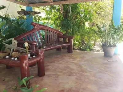 a wooden bench sitting on a patio with plants at Home away from Home in La Villa Isabela in La Isabela