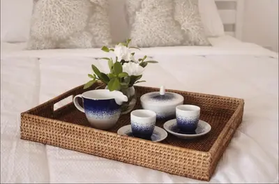 a tray with tea cups and candles on a bed at Albatros by R&R in Villas del Mar
