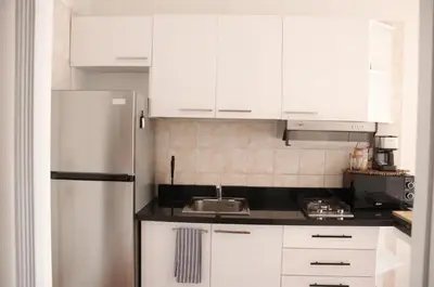 a kitchen with white cabinets and a stainless steel refrigerator at Albatros by R&R in Villas del Mar