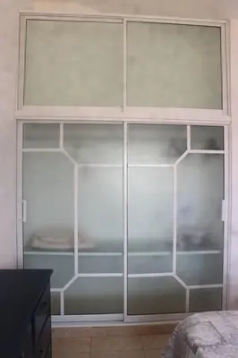 a closet with glass doors in a room at Encantador Apartamento con agua caliente in Los Paredones