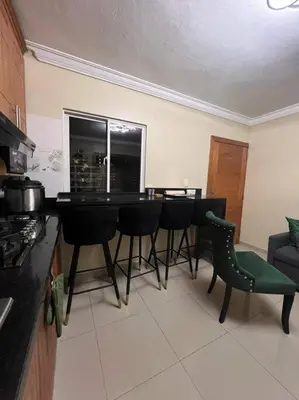 a kitchen with a table and chairs in a room at Apartamento Lujoso En San Pedro de Macoris in San Pedro de Macorís