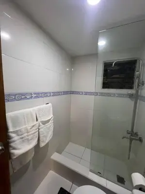 a bathroom with a shower and a toilet and towels at Apartamento Lujoso En San Pedro de Macoris in San Pedro de Macorís