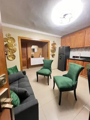 a living room with a couch and two green chairs at Apartamento Lujoso En San Pedro de Macoris in San Pedro de Macorís