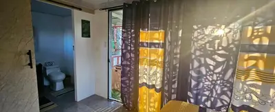 a bathroom with a yellow shower curtain and a toilet at BlueEcolandia Bungalow TIERRA in Jarabacoa