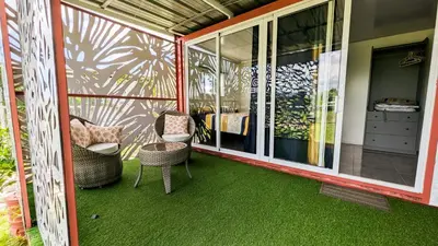 a screened in porch with green flooring and chairs at BlueEcolandia Bungalow TIERRA in Jarabacoa