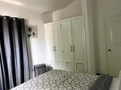 a bedroom with a bed and a white cabinet at Apto CGM Esmeralda in Bayahibe
