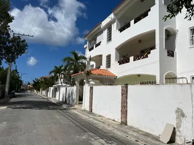 an empty street in front of a white building at Apto CGM Esmeralda in Bayahibe