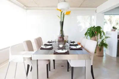 a dining room with a table and white chairs at Casa Phil - Amazing Sea View Luxury Modern, Fully Staffed in Las Terrenas