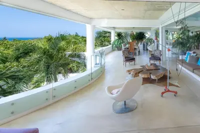 a living room with a white chair and a table at Casa Phil - Amazing Sea View Luxury Modern, Fully Staffed in Las Terrenas