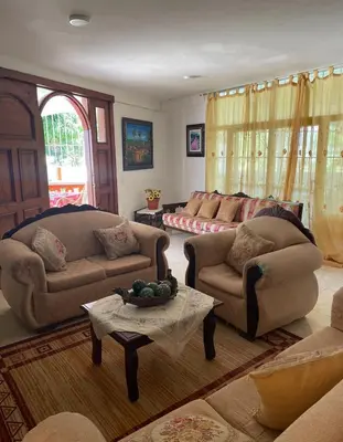 a living room with two couches and a table at Villa Fiordalisa in San Felipe de Puerto Plata
