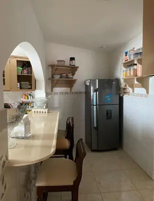 a kitchen with a refrigerator and a table with chairs at Villa Fiordalisa in San Felipe de Puerto Plata