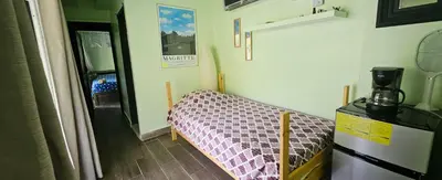 a small room with a bed and a refrigerator at Rincón de Paz in Jarabacoa