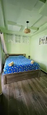 a bedroom with a bed with blue sheets and a ceiling at Rincón de Paz in Jarabacoa
