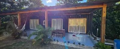 a house with a porch with a table and chairs at Rincón de Paz in Jarabacoa
