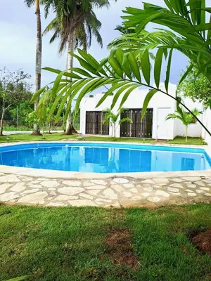 a swimming pool in front of a house at Escapade Apartments in Cabarete