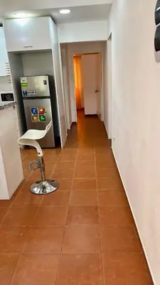 an empty hallway with a chair and a refrigerator at Escapade Apartments in Cabarete