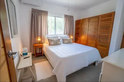 a bedroom with a white bed and a window at Chameleon Village in El Limón