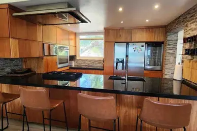 a kitchen with a bar with chairs and a refrigerator at Velero Beach Cabarete 2 bedroom Penthouse in Cabarete