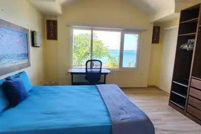a bedroom with a bed and a desk and a window at Velero Beach Cabarete 2 bedroom Penthouse in Cabarete