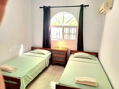 two beds in a small room with a window at Apartamento Oasis PUNTA CANA in Punta Cana