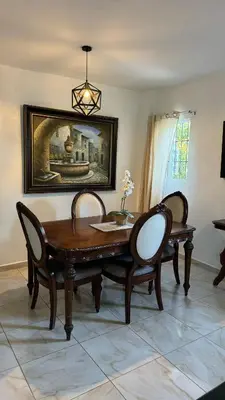 a dining room with a wooden table and two chairs at Céntrico con wifi, luz,gas, TV y aire incluido in La Romana