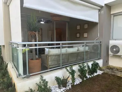 a balcony of a house with a couch and plants at Luxury 2 Bedroom Apartment, 1 Min Walk to Punta Popy Beach, Pool, AC, Fast WiFi, Las Terrenas in Las Terrenas