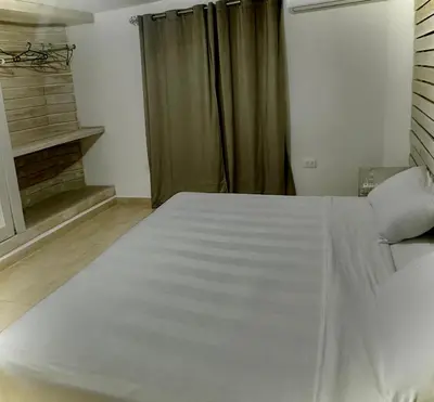 a white bed in a room with a window at Colina Buena Vista A5 in Jarabacoa
