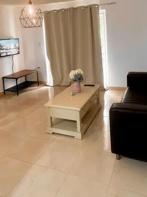 a living room with a vase of flowers on a table at Colina Buena Vista A5 in Jarabacoa