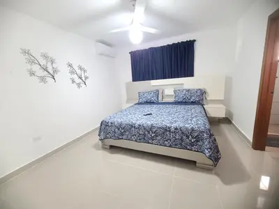 a bedroom with a bed in a white room at Cama king, piscina 3 habitacines in Santiago de los Caballeros
