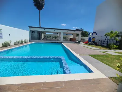 a swimming pool in a yard with a house at Cama king, piscina 3 habitacines in Santiago de los Caballeros