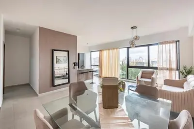 a living room with a glass table and chairs at Encantador Apto en Torre de Lujo, Piscina, AC & Parking in Santo Domingo