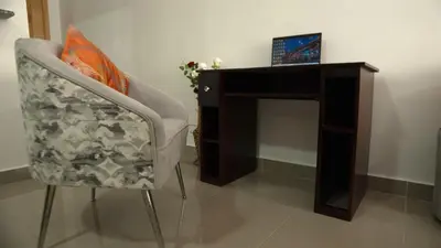 a chair next to a desk with a laptop on it at Apartamento Amaya in Licey