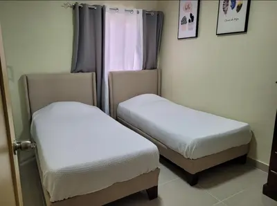 two twin beds in a room with a window at Apartamento Amaya in Licey