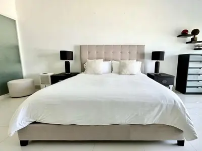 a bedroom with a large white bed with two lamps at Luxury 1 Bedroom with Seaview Seawinds in Cabarete