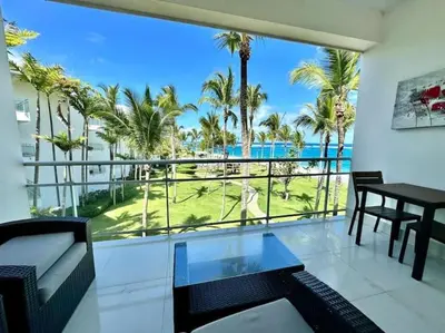 a living room with a view of the ocean and palm trees at Luxury 1 Bedroom with Seaview Seawinds in Cabarete