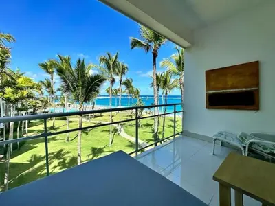 a balcony with a view of the ocean and palm trees at Luxury 1 Bedroom with Seaview Seawinds in Cabarete