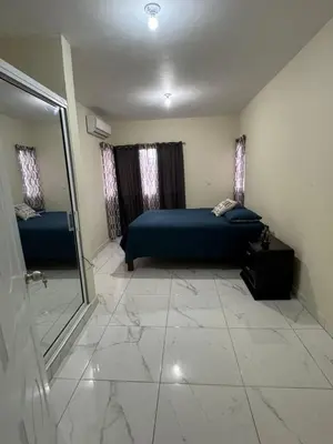a bedroom with a blue bed and a mirror at HEA Stays II in San Felipe de Puerto Plata