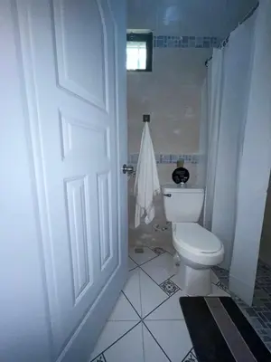 a white bathroom with a toilet and a door at New hotel neo in Santa Cruz de Barahona