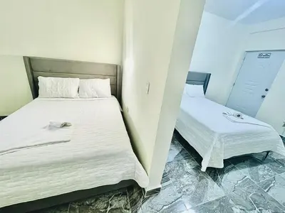 a bedroom with two beds with white sheets at New hotel neo in Santa Cruz de Barahona