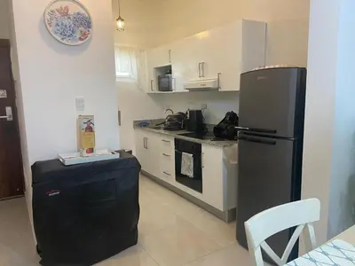 a kitchen with a black refrigerator and a stove at Paraíso Tropical Juan Dolio in Villas del Mar