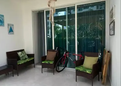 a bike parked in a room with chairs and windows at Paraíso Tropical Juan Dolio in Villas del Mar