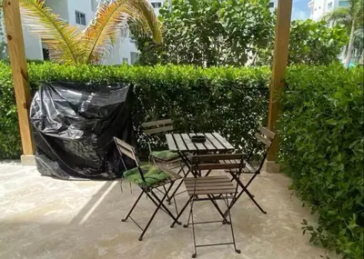a patio with two chairs and a table at Paraíso Tropical Juan Dolio in Villas del Mar