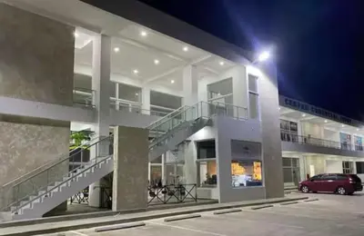 a building with a car parked in a parking lot at Paraíso Tropical Juan Dolio in Villas del Mar