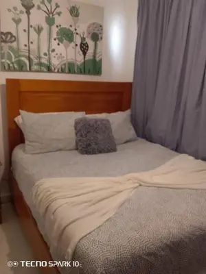 a bed with a wooden headboard and pillows at Paraíso Tropical Juan Dolio in Villas del Mar