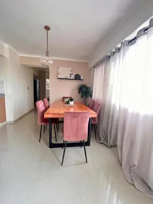 a dining room with a wooden table and pink chairs at Condominio Emilia in Cancino