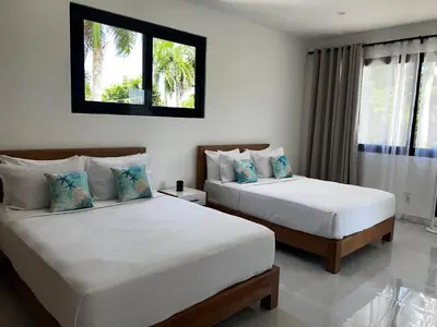 a bedroom with two beds and a window at Villas Montemar - Villa Mar in Las Terrenas