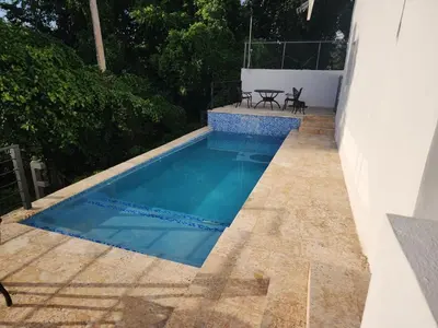 a swimming pool on a patio with a table and chairs at Villas Montemar - Villa Sol in Las Terrenas