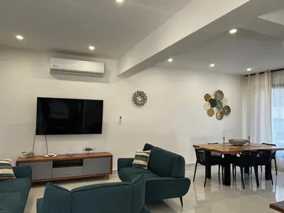 a living room with a tv and a dining room at Villas Montemar - Villa Sol in Las Terrenas